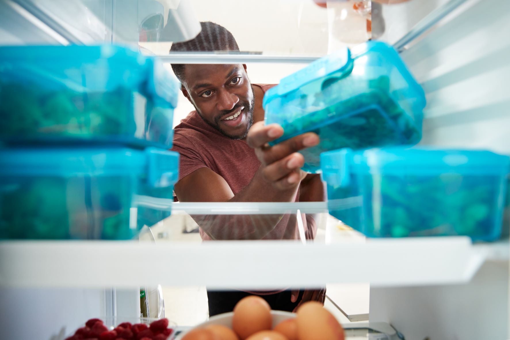 man taking his prepped meal out of the fridge