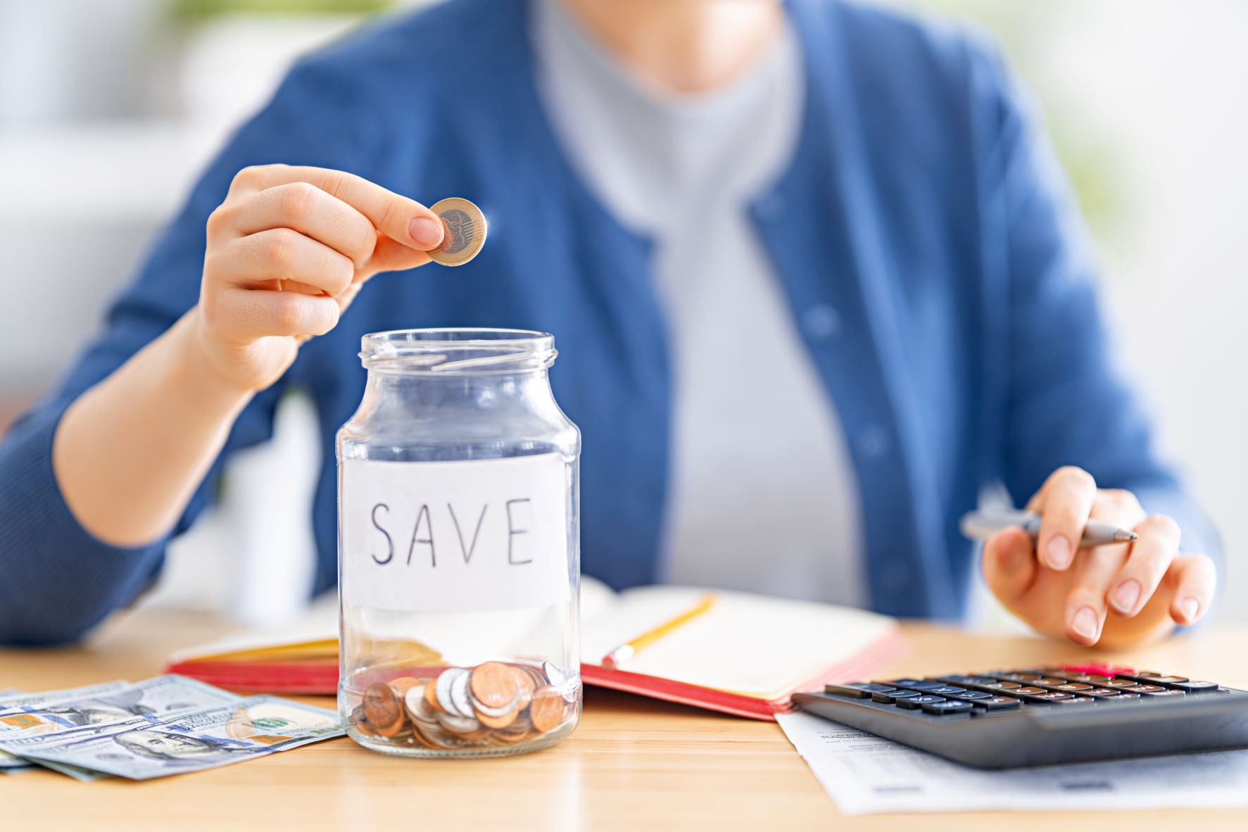 woman putting change into a money saving jar